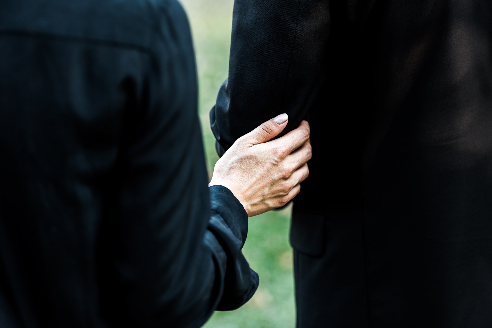 Cropped view of woman touching senior man on funeral